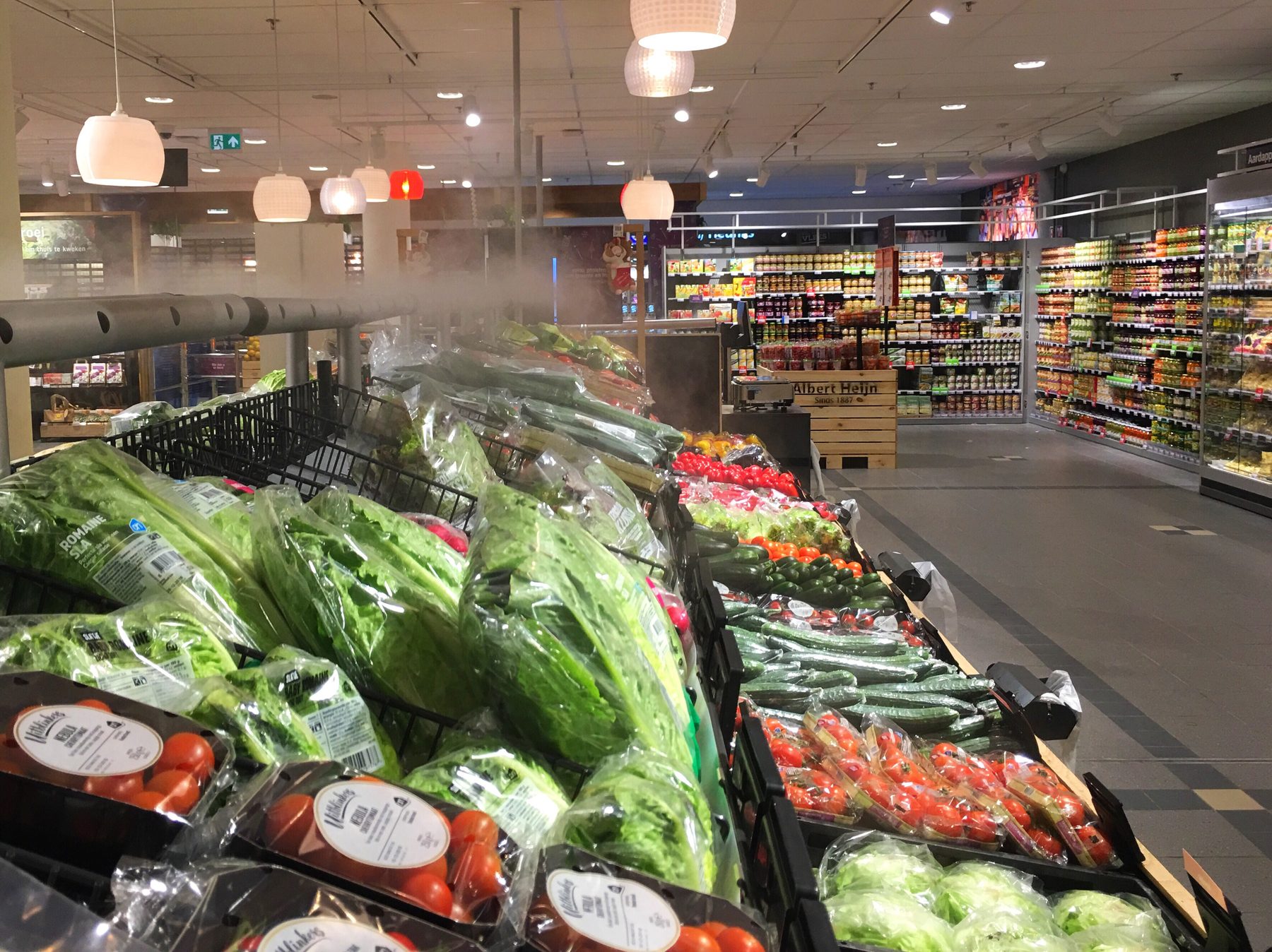 A supermarket fresh produce aisle under misting sprayers